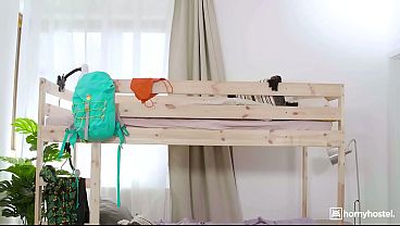 Big-Titted Brunette Guides Her Roommate’s Mouth Down Her Body on the Hostel Bed